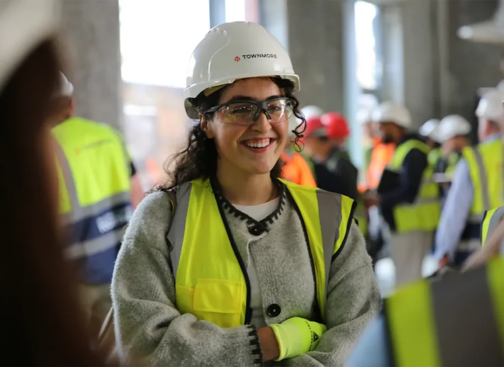Young woman in group wearing protective construction equipment