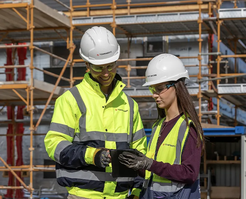 Man and woman in ahrd hat on construction site