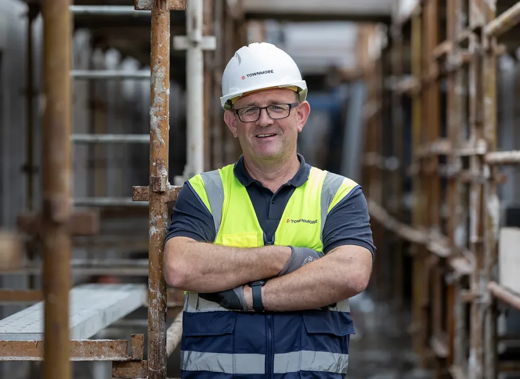 Townmore worker standing with arms crossed in scaffolding path